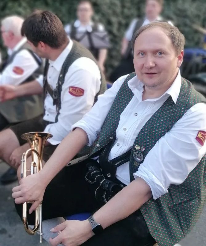 Erster Vorsitzender Matthias Nitsch bei einem Auftritt mit Flügelhorn und in Vereinstracht lächelt in die Kamera