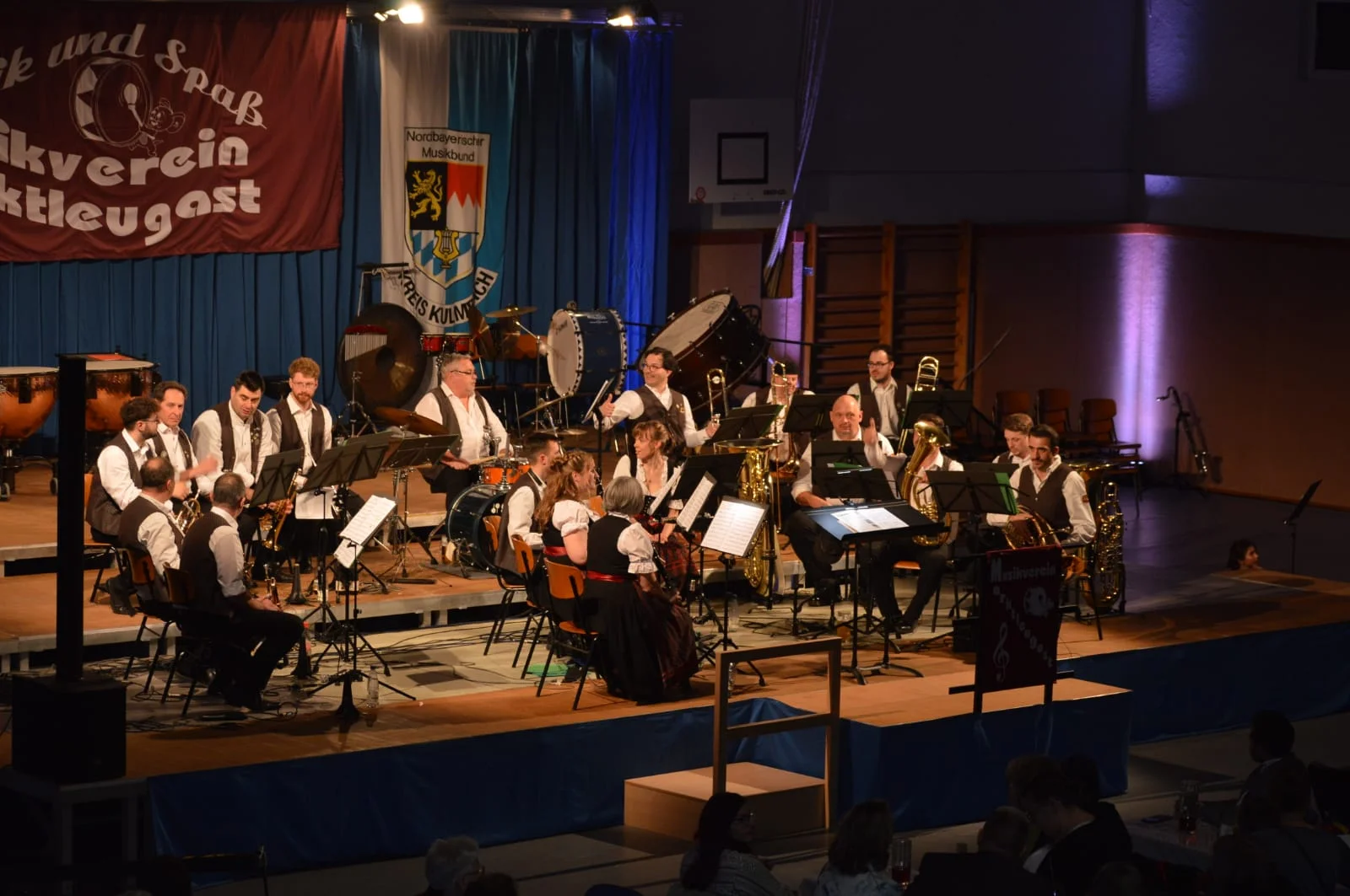 Im letzen Teil des Konzertes sitzen weniger Musikerinnen und Musiker auf der Bühne. Sie tragen die Vereinsweste und ein weißes Hemd des Musikvereins.